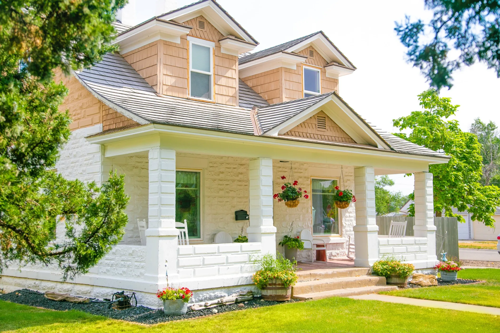 Craftsman-style home with a covered front porch and hanging plants