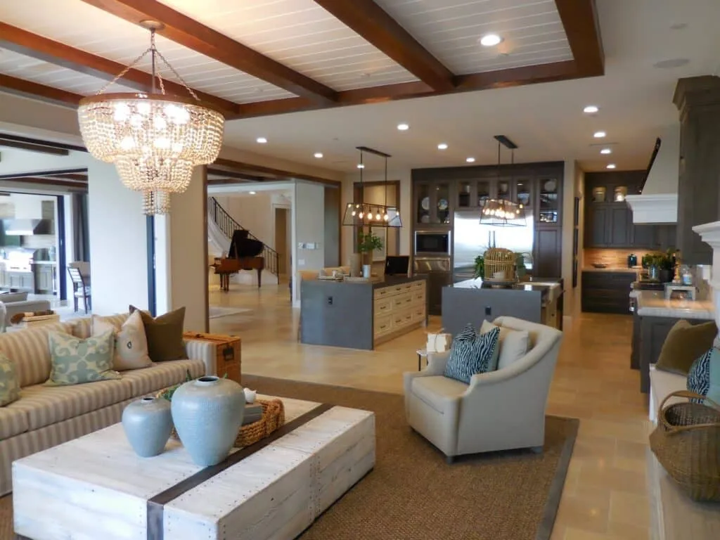 Open living room and kitchen with a wood-beam ceiling and a chandelier