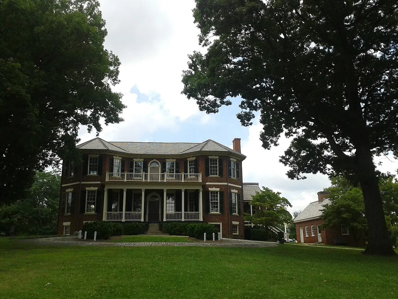 Point of Honor, a brick mansion with a two-story porch, framed by oak trees