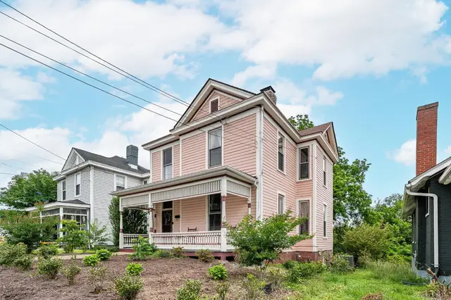 Front of the pink two-story Victorian house with a wraparound front porch at 1011 16th Street, Lynchburg VA