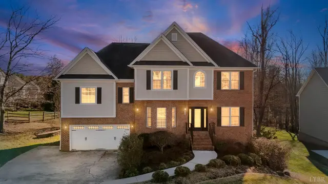 Front of the two-story brick house with a two-car garage at dusk at 1040 Hooper Woods Drive, Forest VA