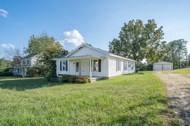 Side view of the house with a detached garage and gravel drive at 10435 Red House Road, Appomattox VA