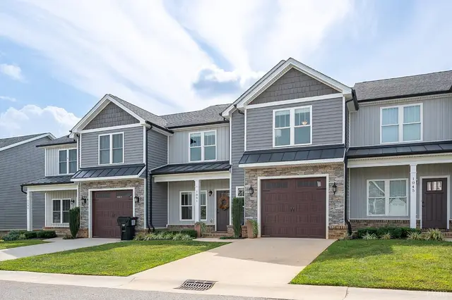 Front of the townhomes with garages and a green lawn at 1051 Cobblestone Lane, Forest VA