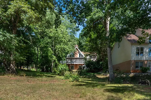 Backyard with mature trees and the house beyond at 107 Waterview Circle, Forest VA