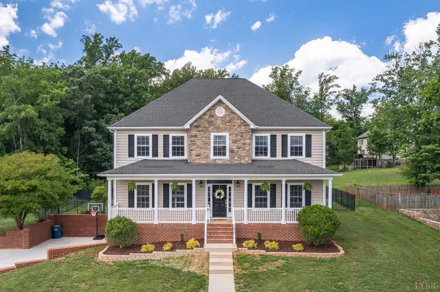 Front of the two-story house with a stone front and covered porch at 1075 Hooper Woods Drive, Forest VA