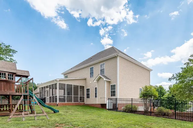 Back of the house with a screened porch and a play set at 1075 Hooper Woods Drive, Forest VA