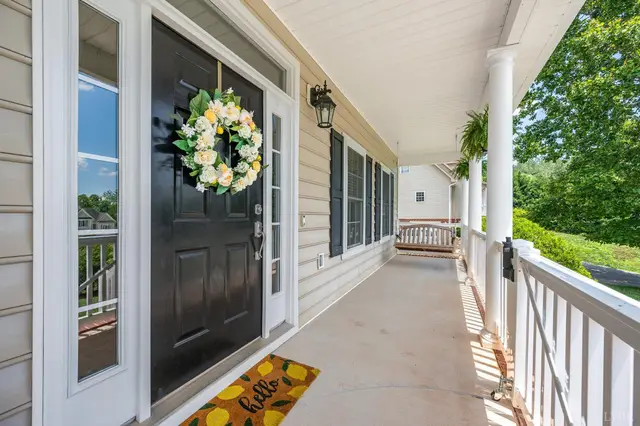Front porch with a black front door and white railings at 1075 Hooper Woods Drive, Forest VA
