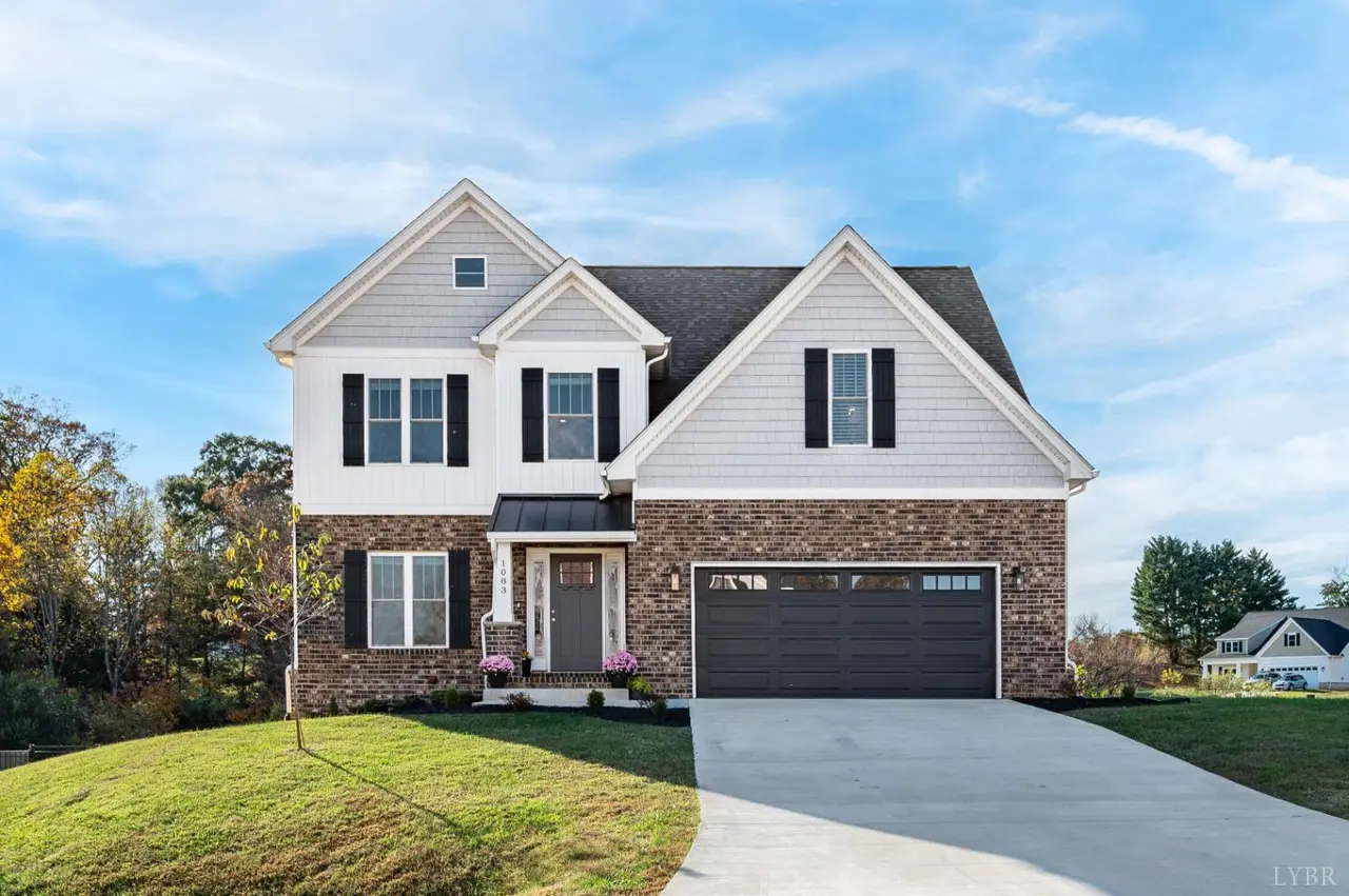 Front of the house with white siding, brick, and a two-car garage at 1083 Boonsboro Meadows Drive, Lynchburg VA