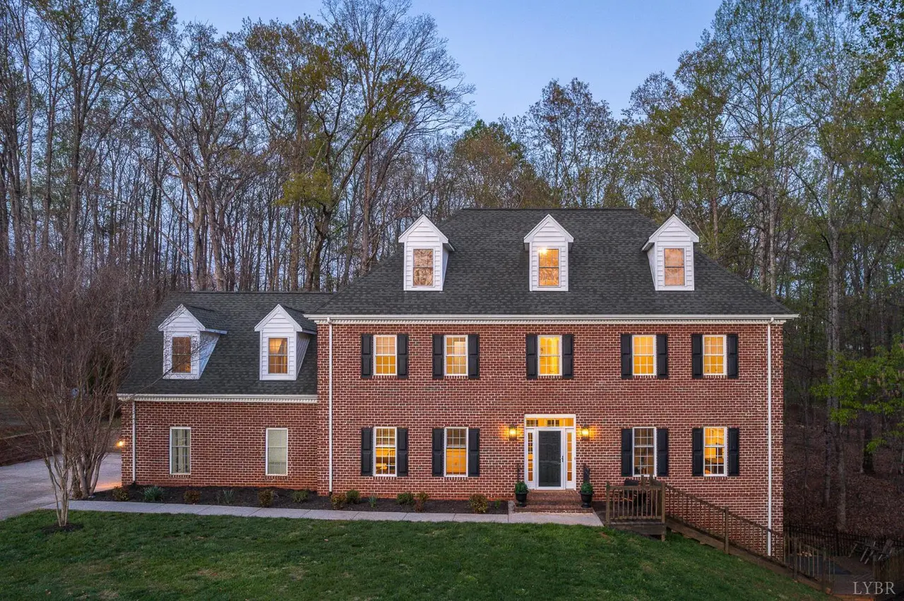 Front of the brick house with dormers at dusk at 1089 Howards Scenic Trail, Forest VA