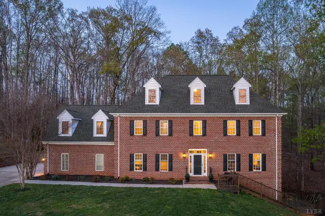 Front of the brick house with dormers at dusk at 1089 Howards Scenic Trail, Forest VA