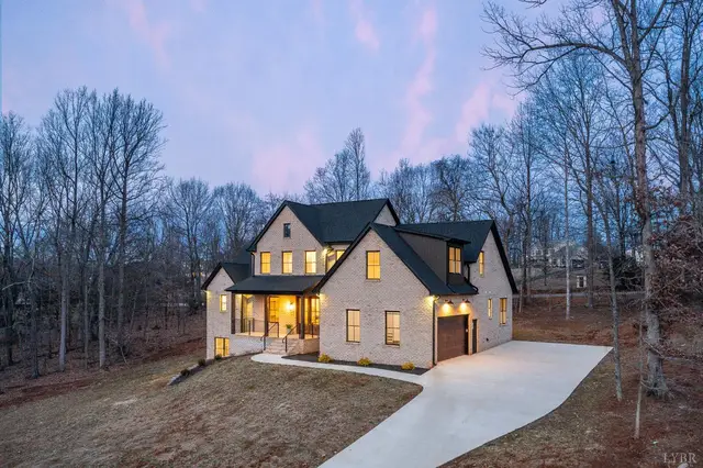 Front of the brick two-story house at dusk with a long driveway at 1148 Val Terrace Court, Forest VA