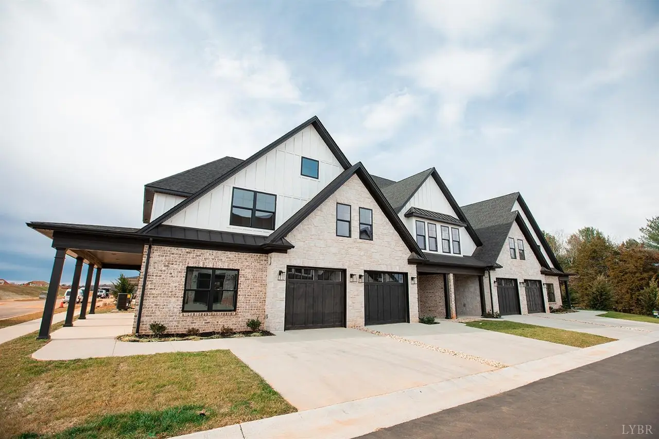 Front of the townhomes with black garage doors and white brick at 1151 South Westyn Loop, Forest VA