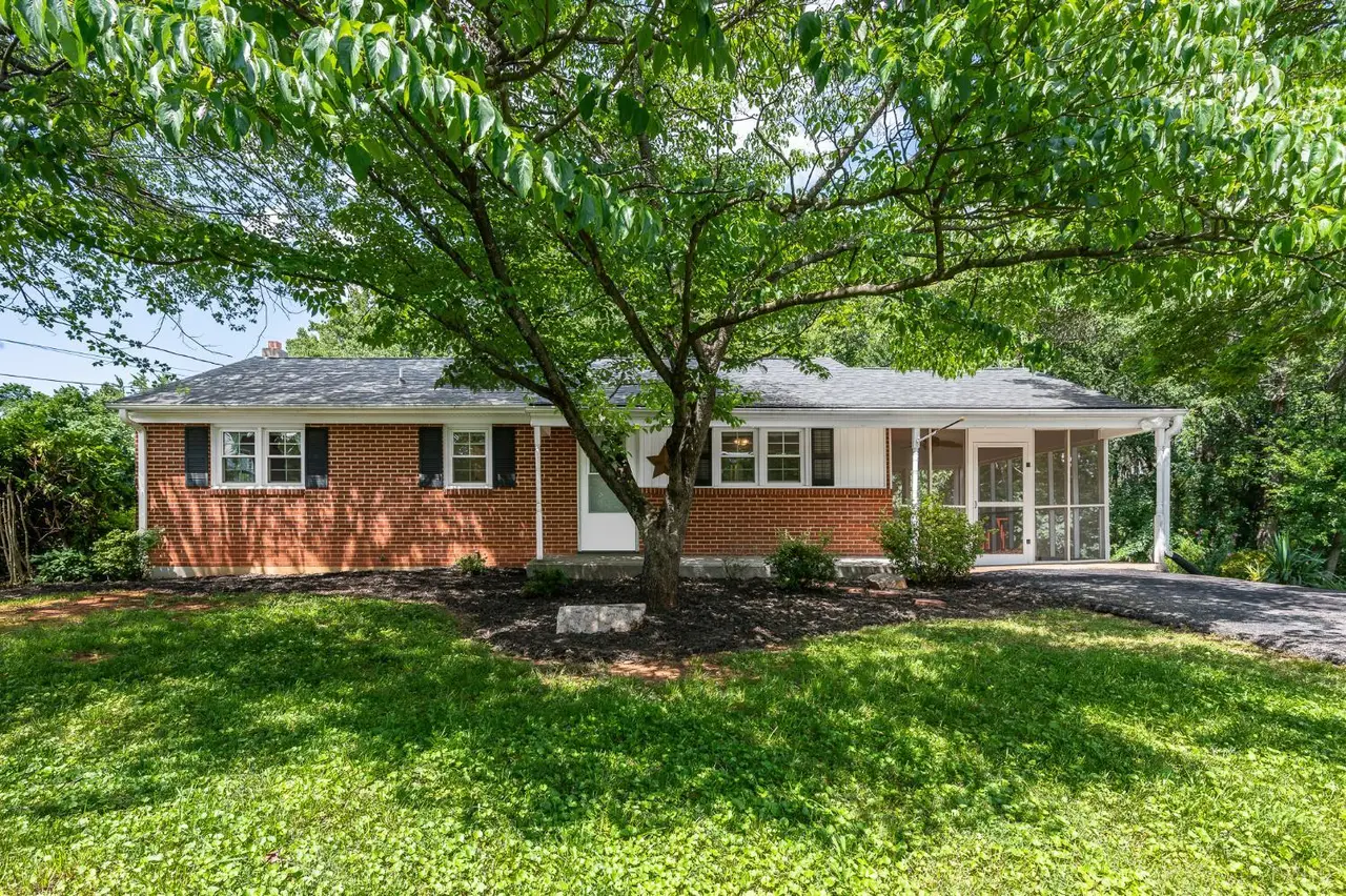 Front of the house, brick ranch with a screened side porch under large trees at 116 Walton Drive, Lynchburg VA