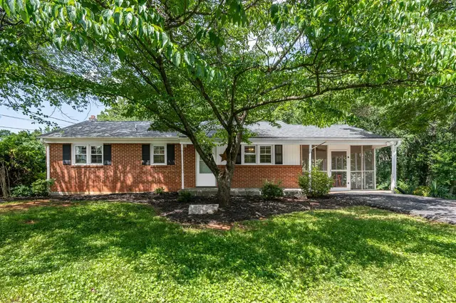 Front of the house, brick ranch with a screened side porch under large trees at 116 Walton Drive, Lynchburg VA
