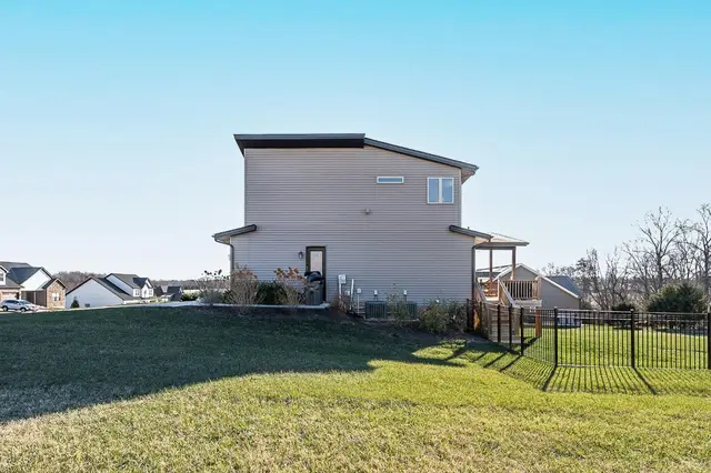 Back of the house with a lawn, black metal fence and covered rear porch at 1172 Jefferson Meadows Drive, Forest VA