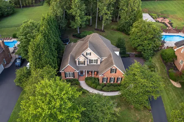 Aerial view of the house with a curved front walkway and wooded lot at 1227 Jefferson Dr W, Forest VA
