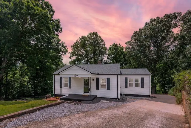 Front of the house, white one-story with black shutters and gravel drive at sunset at 1229 Stratford Road, Lynchburg VA