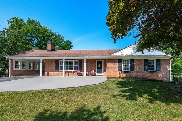 Front of the house, brick ranch with a columned porch and wide driveway at 1246 Rainbow Forest Drive, Lynchburg VA
