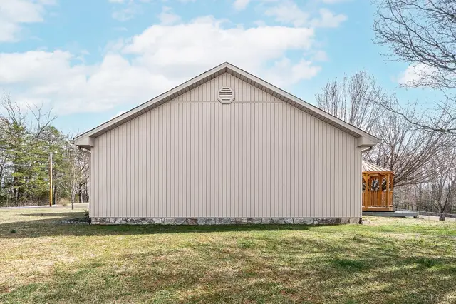 Side of the house with vertical siding and a lawn at 1247 Navigation Point, Goodview VA
