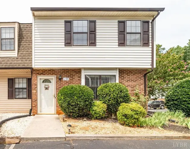 Front of the townhouse, two-story with a brick lower level and black shutters at 131 Cape Charles Square, Lynchburg VA