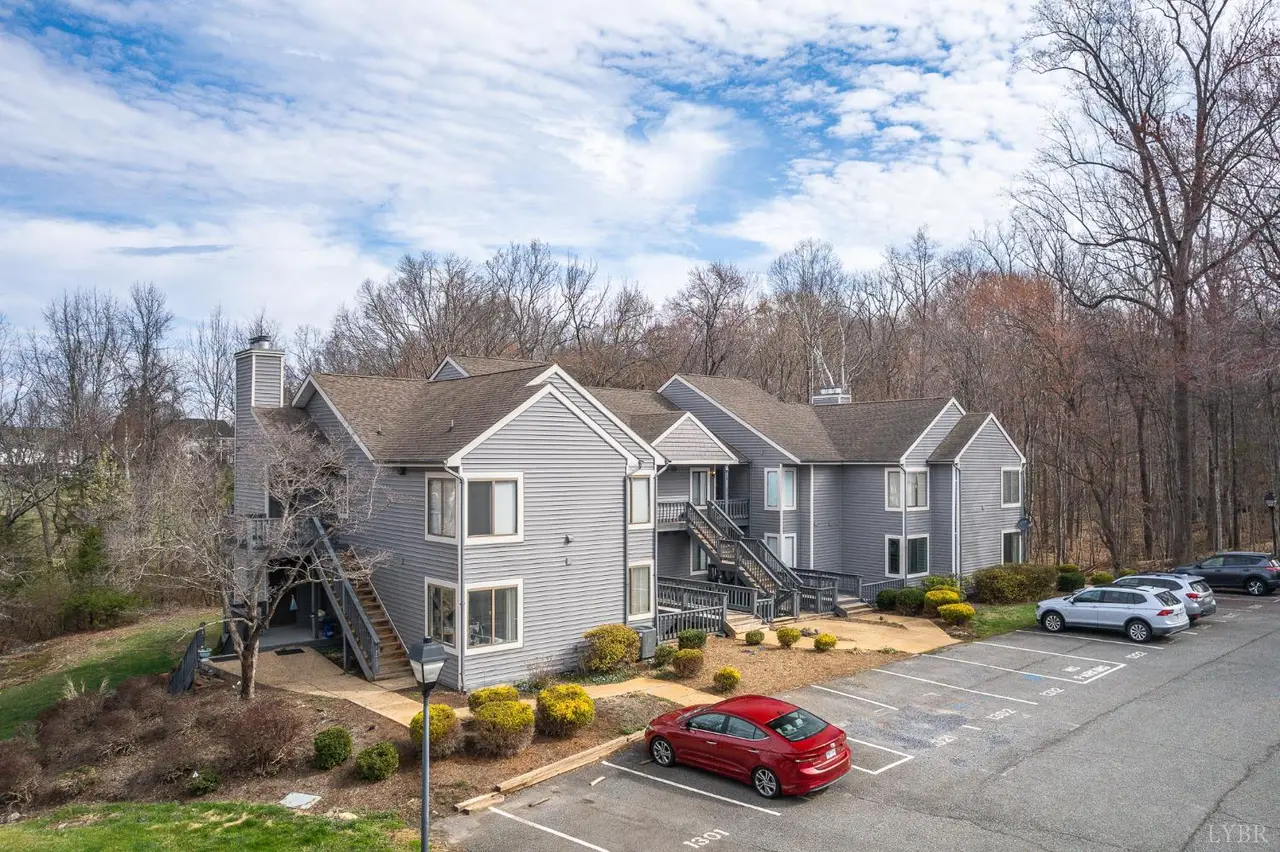 Aerial view of the condo building with gray siding and a parking lot at 1314 Twin Springs Court, Forest VA