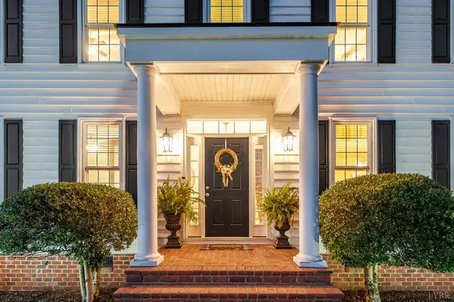 Front entry with white columns, a black door and brick steps at 1351 Country Estates Drive, Lowry VA
