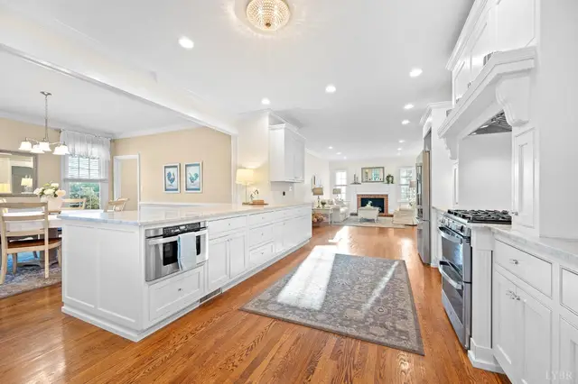 Kitchen with a long white island and a double oven range, open to the living room at 1351 Country Estates Drive, Lowry VA