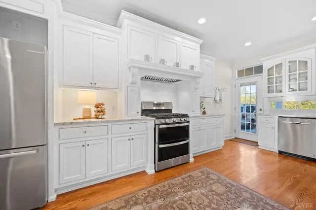 Kitchen with a gas range under a white hood and a stainless refrigerator at 1351 Country Estates Drive, Lowry VA