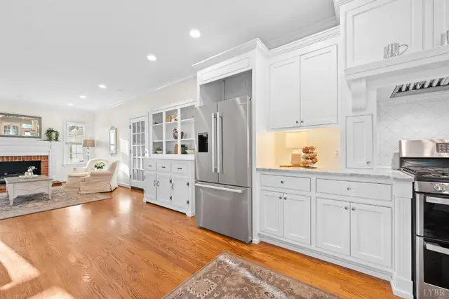 Kitchen with a stainless refrigerator, looking into the living room fireplace at 1351 Country Estates Drive, Lowry VA