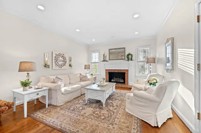 Living room with a brick fireplace and white slipcovered sofas at 1351 Country Estates Drive, Lowry VA