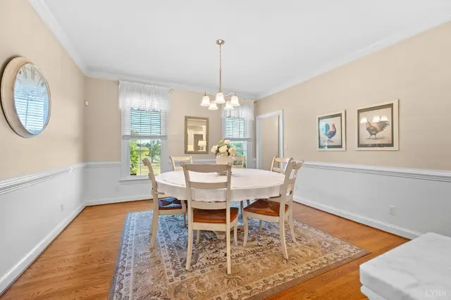 Dining room with a round table, chandelier and chair rail wainscoting at 1351 Country Estates Drive, Lowry VA