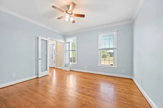 Empty sitting room with glass French doors and hardwood floors at 1351 Country Estates Drive, Lowry VA