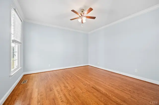 Empty room with light blue walls, a ceiling fan and hardwood floors at 1351 Country Estates Drive, Lowry VA