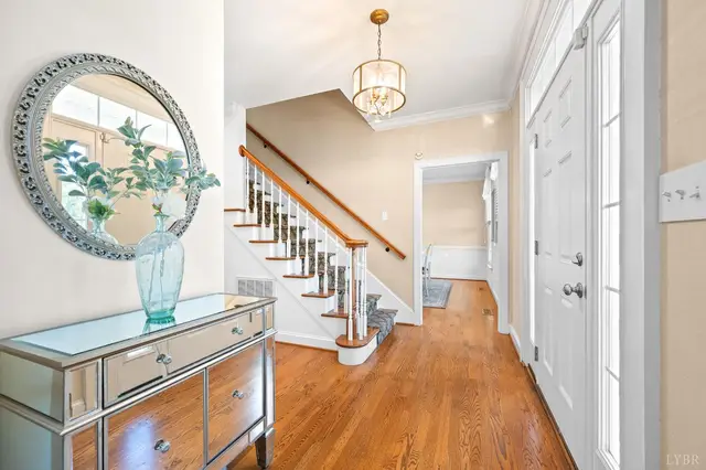 Entry hall with a staircase, round mirror and pendant light at 1351 Country Estates Drive, Lowry VA