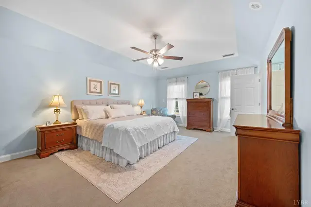 Bedroom with a tray ceiling, ceiling fan and cherry wood furniture at 1351 Country Estates Drive, Lowry VA