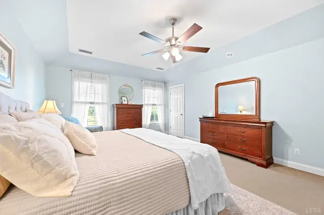 Bedroom with a cherry dresser and mirror between two windows at 1351 Country Estates Drive, Lowry VA