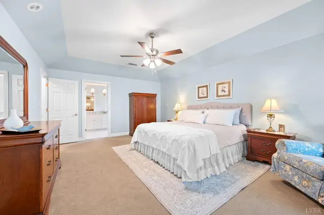 Bedroom with a tray ceiling and a doorway to the bathroom at 1351 Country Estates Drive, Lowry VA