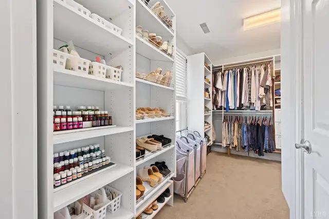 Walk-in closet with white shelving for shoes and bins at 1351 Country Estates Drive, Lowry VA