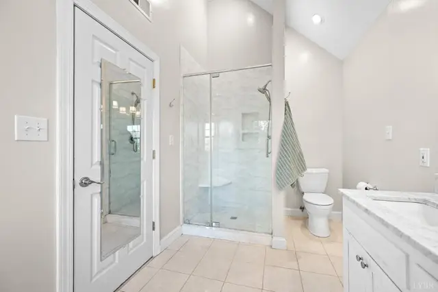 Bathroom with a glass shower and a door with a full-length mirror at 1351 Country Estates Drive, Lowry VA