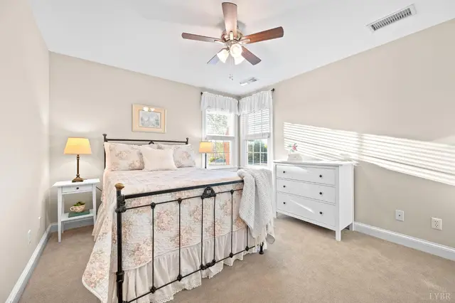 Bedroom with an iron bed, a ceiling fan and two windows at 1351 Country Estates Drive, Lowry VA