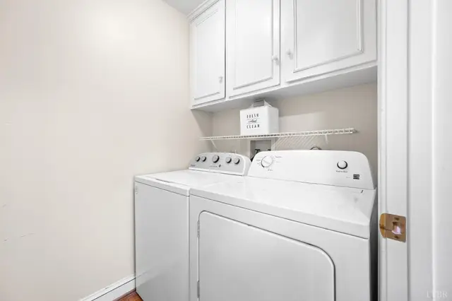 Laundry room with a white washer and dryer under wall cabinets at 1351 Country Estates Drive, Lowry VA