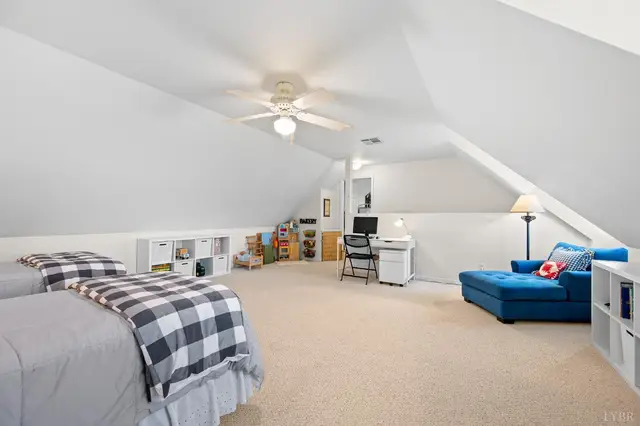 Bedroom with sloped ceilings, a desk area and a blue chaise at 1351 Country Estates Drive, Lowry VA