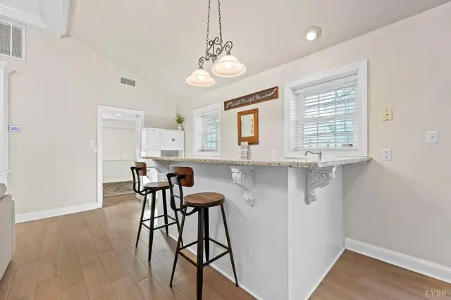 Breakfast bar with a granite top, stools and pendant lights at 1351 Country Estates Drive, Lowry VA