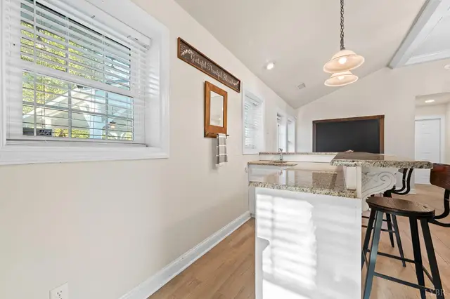 Breakfast bar with stools under a vaulted ceiling by a window at 1351 Country Estates Drive, Lowry VA