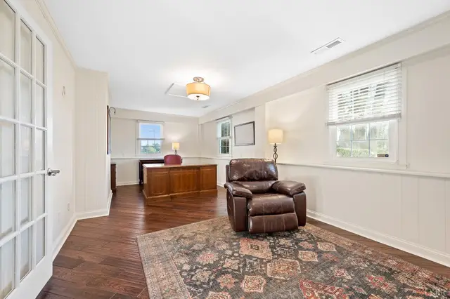 Sitting room with dark hardwood floors, a leather recliner and glass French doors at 1351 Country Estates Drive, Lowry VA