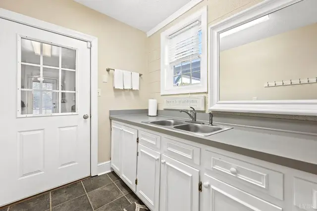 Mudroom with white cabinets, a utility sink and an exterior door at 1351 Country Estates Drive, Lowry VA