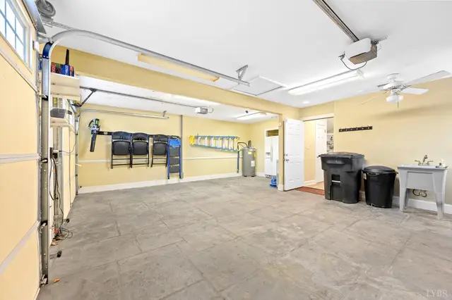 Garage with yellow walls, a utility sink and a door to the house at 1351 Country Estates Drive, Lowry VA