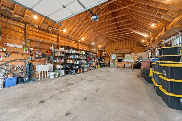 Workshop with exposed wood rafters and shelving at 1351 Country Estates Drive, Lowry VA