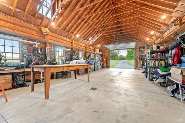 Workshop with a long workbench and an open garage door at 1351 Country Estates Drive, Lowry VA