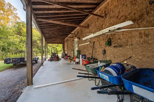 Covered lean-to on the side of the garage with wheelbarrows at 1351 Country Estates Drive, Lowry VA